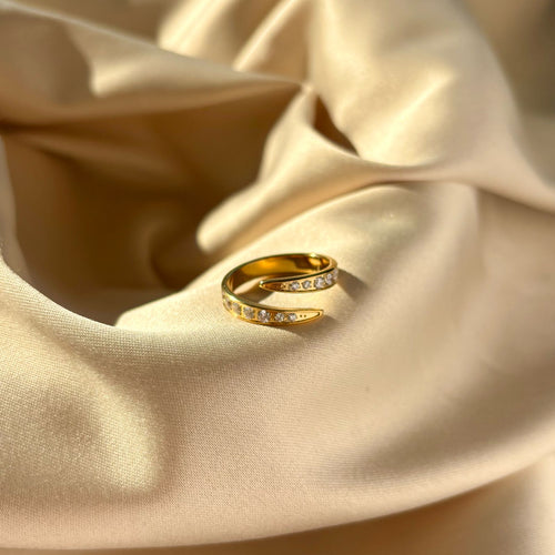 Gold ring with small diamonds on beige satin fabric