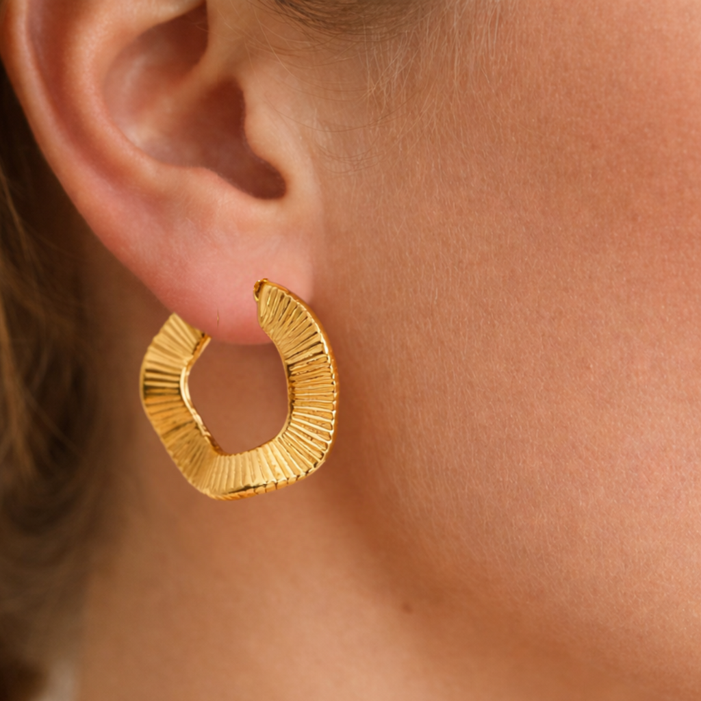 Gold hoop earring worn by a person