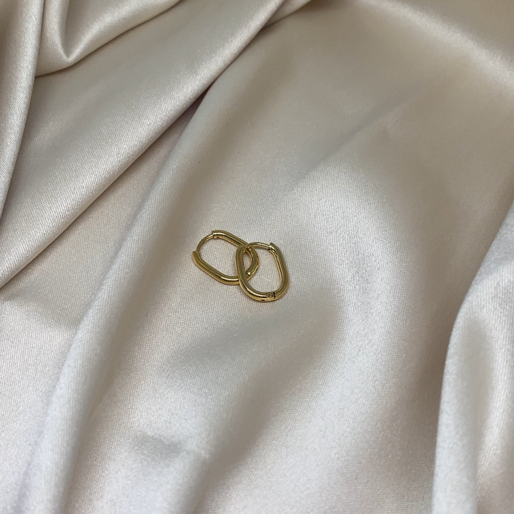 Gold ring on a textured beige fabric surface